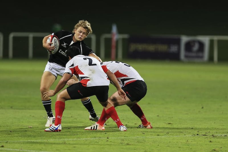 UAE’s Charlie Sargent tries to avoid a tackle by Singapore team members during the one-off Division 1 Test at The Sevens. The Singapore-born winger was making his debut. Sarah Dea / The National