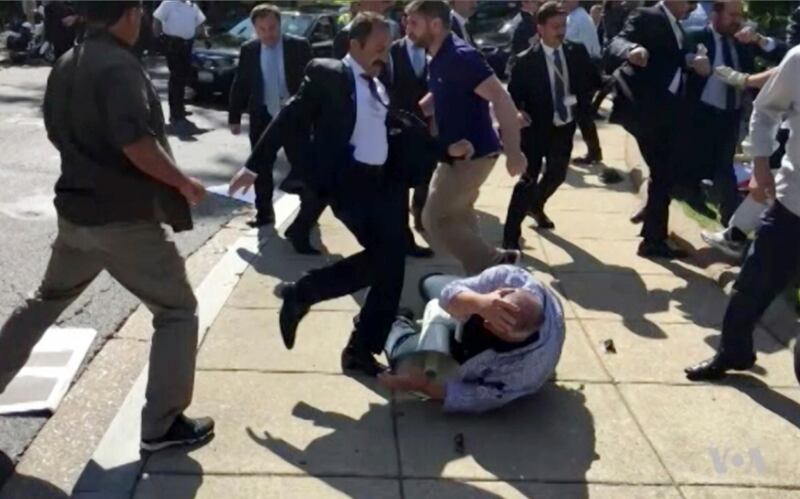 FILE- In this file frame grab from video provided by Voice of America, members of Turkish President Recep Tayyip Erdogan's security detail are shown violently reacting to peaceful protesters during Erdogan's trip last month to Washington. A grand jury in the U.S. capital announced Tuesday, Aug. 29, 2017, that it issued indictments for 19 people, including 15 identified as Turkish security officials, for attacking protesters in May 2017. (Voice of America via AP, File)