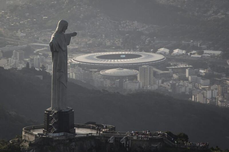 In this May 13, 2014, photo, an aerial view shot through an airplane window shows the Maracana stadium behind the Christ the Redeemer statue in Rio de Janeiro, Brazil. Felipe Dana / AP