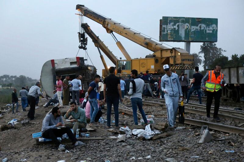 People break their Ramadan fast hours after a passenger train derailed near Banha, the capital of Qalyubia province, Egypt. AP Photo