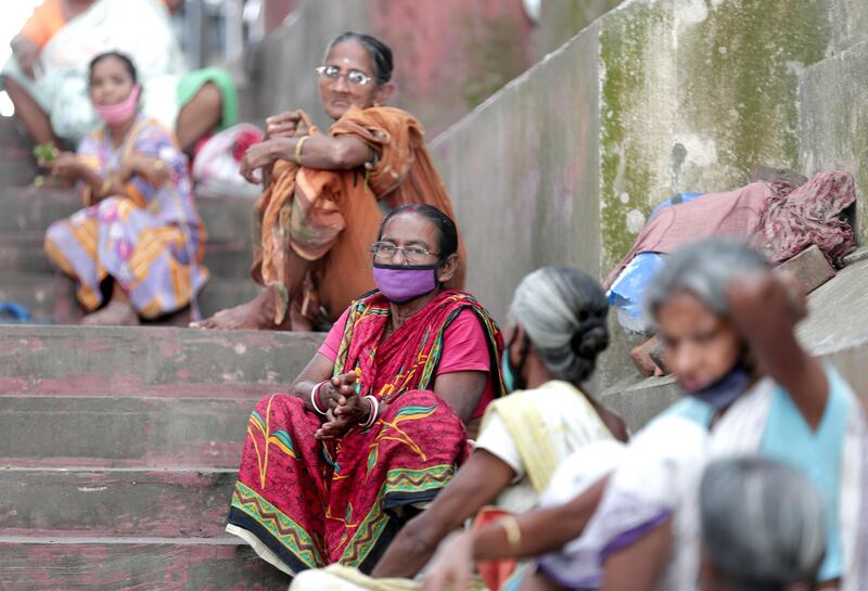 Homeless women wear protective face masks as they wait for free food near a market area during a lockdown in place to prevent the spread of coronavirus in Kolkata, India. According to media reports, Prime Minister Modi announced that India's initial 21-day lockdown will be extended until 03 May 2020 in an attempt to curb the spread of coronavirus.  EPA