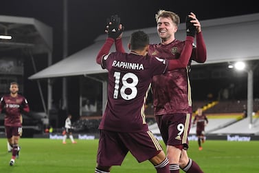 Leeds United's Raphinha celebrates with Leeds United's Patrick Bamford after scoring his side's second goal during the English Premier League soccer match between Fulham and Leeds United, at Craven Cottage stadium, London, Friday, March 19, 2021. (Andy Rain/Pool via AP)
