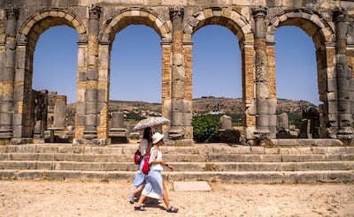 Tourists walk through the ruins of the ancient Roman site of Volubilis, near the town of Moulay Idriss Zerhounon in Morocco's north central Meknes region, on July 25, 2018. - Situated in the centre of a fertile plain at the foot of Mount Zerhoun, the towering remains of Morocco's oldest Roman site, Volubilis, were long neglected.
But after decades of looting and decay, custodians of the now closely guarded ancient city are turning the page and attracting back tourists. (Photo by FADEL SENNA / AFP)