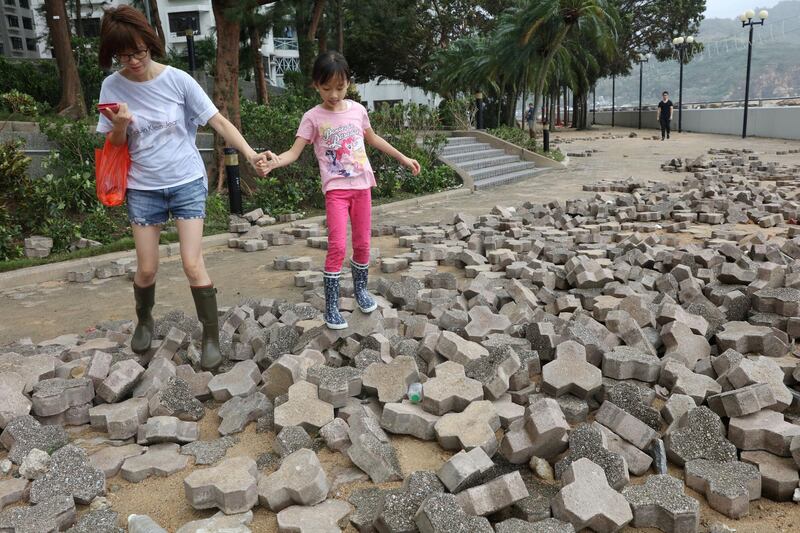 People walk on a broken pavement after Typhoon Mangkhut hit Hong Kong. Reuters