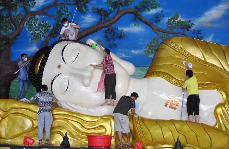 Workers at a temple in Bogor, West Java province, Indonesia, clean a giant Buddha statue to anti-coronavirus standards in preparation for Lunar New Year celebrations. Reuters