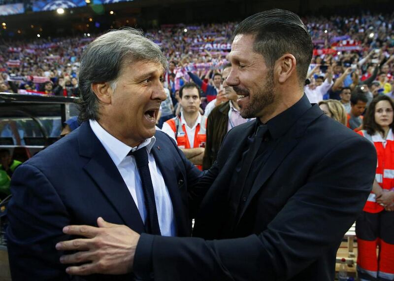 Atletico Madrid manager Diego Simeone, right, greets FC Barcelona head coach Gerardo Martino before their Champions League match at the Vicente Calderon Stadium on Wednesday. Juanjo Martin / EPA / April 9, 2014