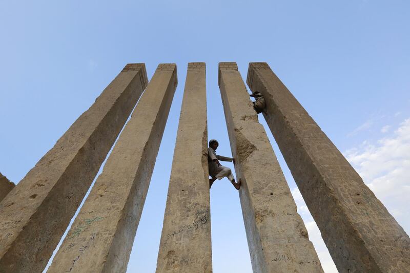 Yemenis climb the columns of an archaeological site, called the throne of Bilqis, in the eastern province of Marib, Yemen. EPA