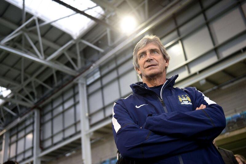 Manchester City's then manager Manuel Pellegrini observes youth footballers during the launch of the new City Football Academy on Monday. AFP