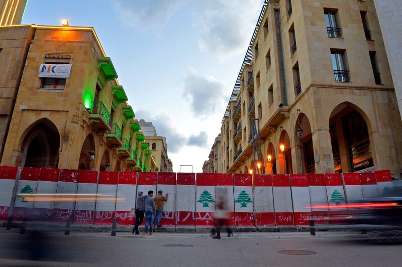 People walk next to a concrete wall set up by Lebanese police to block a road leading to the parliament building in downtown Beirut, Lebanon.  EPA