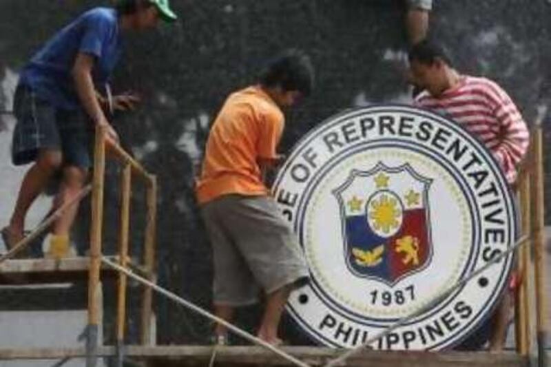 epa02260181 Filipino workers put up a logo of the House of Representatives in Quezon City, east of Manila, Philippines 25 July 2010. President Benigno Aquino III, son of the late president Corazon Aquino, is set to deliver on 26 July his first State of the Nation Address (SONA) to the country at the House of Representatives at the opening of the 15th Congress less than a month since taking his oath of office.  EPA/ROLEX DELA PENA *** Local Caption ***  02260181.jpg