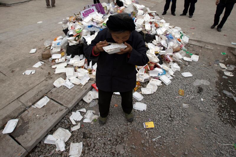 An elderly woman eats a meal near rubbish piled up at a center for evacuees in the county seat of Lushan in southwestern China's Sichuan province, Sunday, April 21, 2013. Rescuers and relief teams struggled to rush supplies into the rural hills of China's Sichuan province Sunday after the earthquake prompted frightened survivors to spend a night in cars, tents and makeshift shelters. (AP Photo/Ng Han Guan) *** Local Caption ***  APTOPIX China Earthquake.JPEG-019f3.jpg