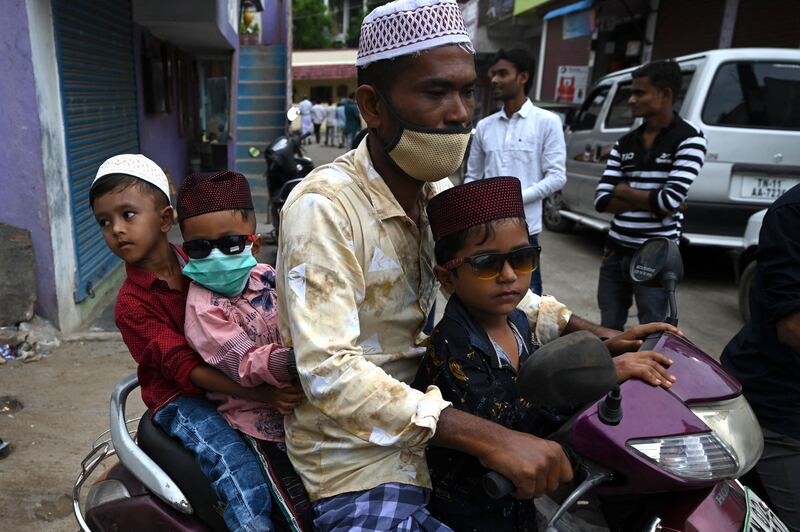 A Rohingya Muslim refugee and children ride a scooter during Eid Al Adha at a refugee camp on the outskirts of Chennai, India.