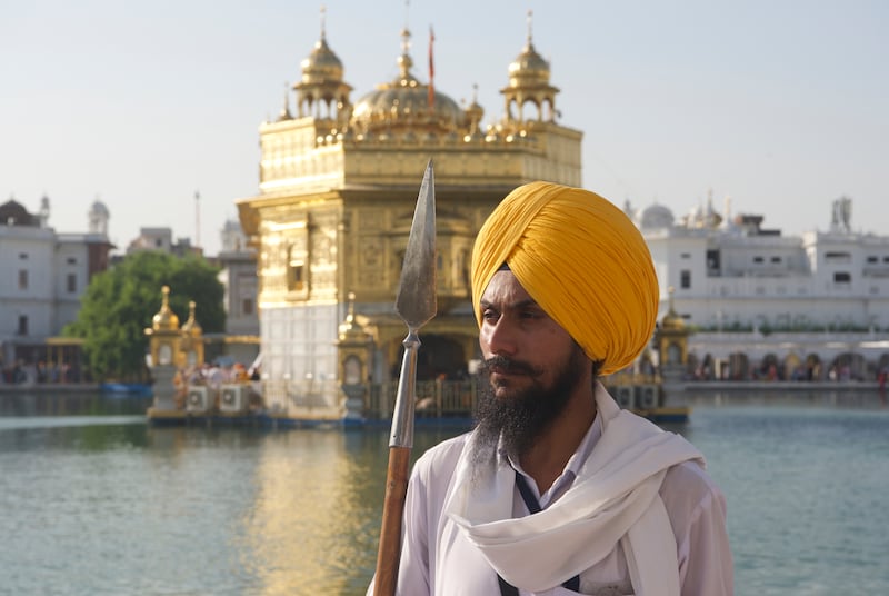 A Sikh volunteer armed with a spear stands in front of the Golden Temple, the holiest site in Sikhism, in the Indian city of Amritsar in Punjab state. Taniya Dutta for The National.