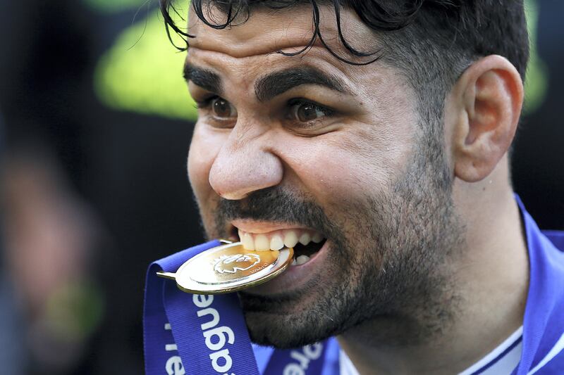 Chelsea's Brazilian-born Spanish striker Diego Costa poses with his winner's medal, as players celebrate their league title win at the end of the Premier League football match between Chelsea and Sunderland at Stamford Bridge in London on May 21, 2017.
Chelsea's extended victory parade reached a climax with the trophy presentation on May 21, 2017 after being crowned Premier League champions with two games to go.  / AFP PHOTO / Ian KINGTON / RESTRICTED TO EDITORIAL USE. No use with unauthorized audio, video, data, fixture lists, club/league logos or 'live' services. Online in-match use limited to 75 images, no video emulation. No use in betting, games or single club/league/player publications.  / 