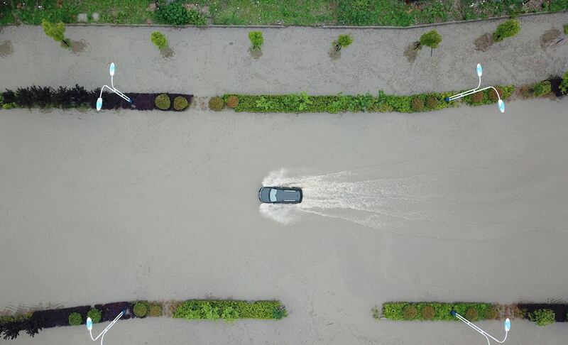 A car drives through a water-logged street after heavy rainfall in Yangzhou in China's eastern Jiangsu province on May 25, 2018.  Heavy rain swept parts of east China on May 25. - China OUT
 / AFP / -
