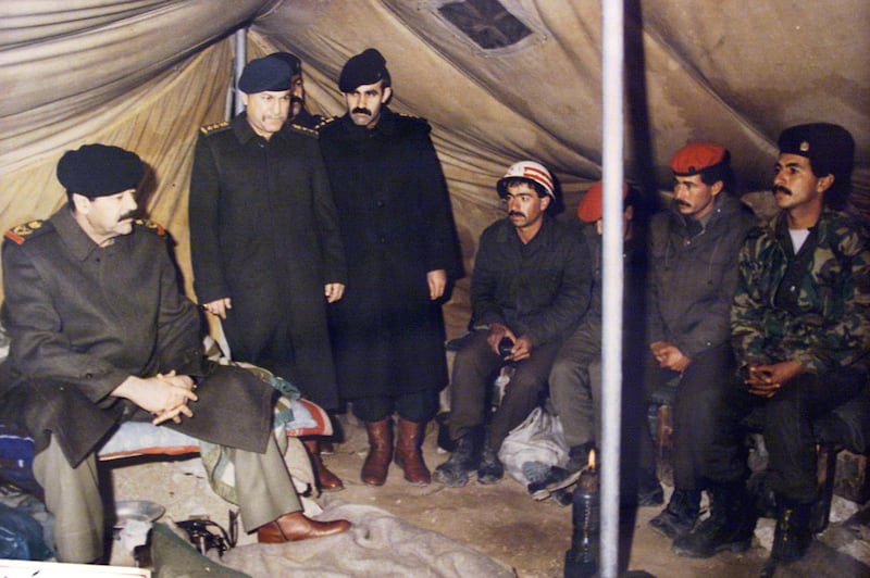 (FILES) In this photograph made available by the official Iraqi presidential photographer on 26 April 2002, Iraqi President Saddam Hussein (L) is seen sitting in a tent in Najaf (Irak) in 1991 during Gulf War, with unidentified others. Thirty years have passed since Iraqi tyrant Saddam Hussein invaded neighbouring Kuwait, but despite hints of a diplomatic rapprochement, people both countires say the wounds have yet to heal. On August 2, 1990, Saddam sent his military, already exhausted by an eight-year conflict with Iran, into Kuwait to seize what he dubbed "Iraq's 19th province." The two-day operation turned into a seven-month occupation and, for many Iraqis, opened the door to 30 years of devastation which is still ongoing. / AFP / PRESIDENTIAL PALACE / -
