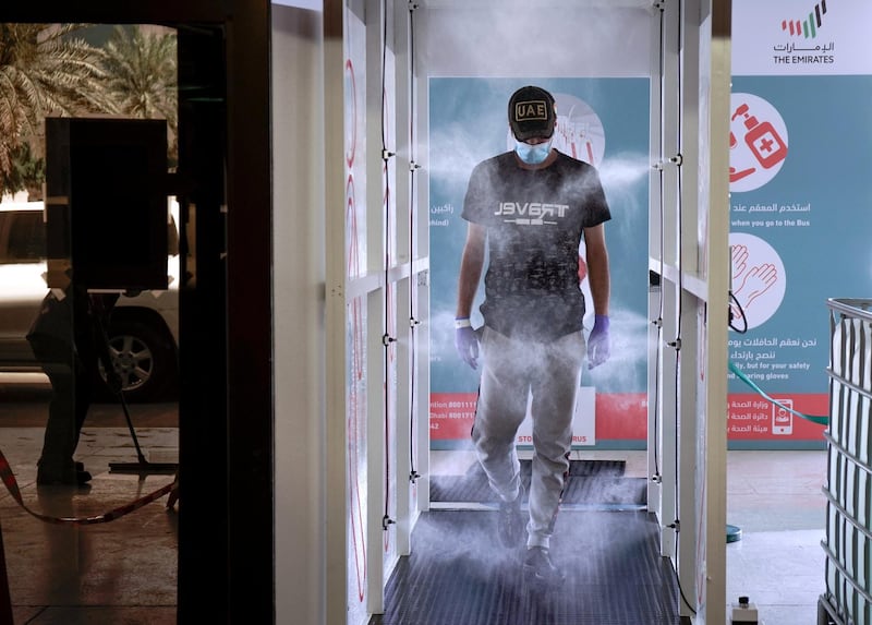 Abu Dhabi, United Arab Emirates, March 31, 2020. 
  A commuter enters the new sterilization area  and gets sprayed at the entrance of the Abu Dhabi Central Bus Terminal.
Victor Besa / The National
Section:  NA
Reporter: