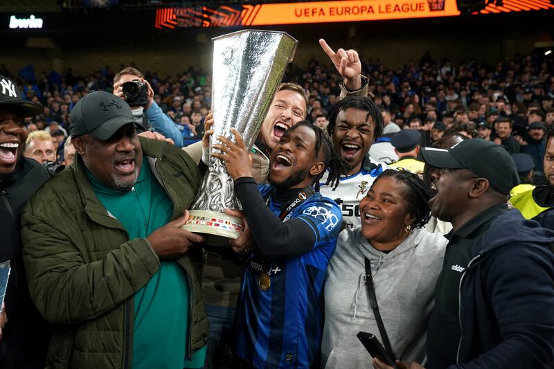 Ademola Lookman with father Felix (left) and family members as they celebrate with the trophy. PA