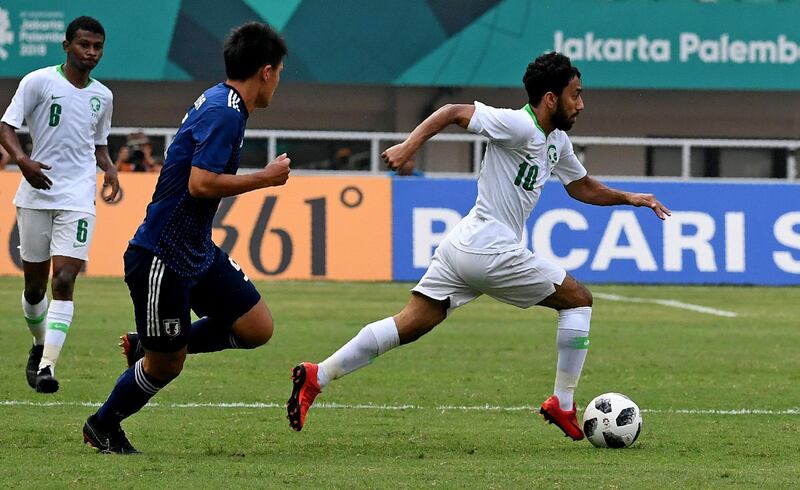 Japan's Daiki Sugioka (C) chases after Saudi Arabia's Ayman Shafiq Alkhulaif (R) during the men's quarter-final football match between Japan and Saudi Arabia at the 2018 Asian Games in Jakarta on August 27, 2018. (Photo by MONEY SHARMA / AFP)