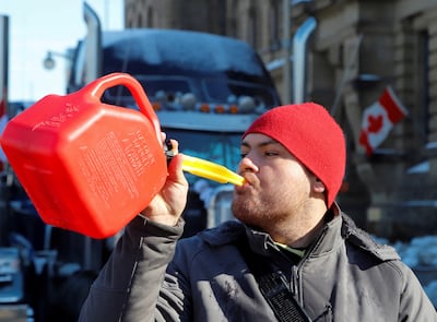 A man pretends to drink from a fuel can after police said they will be targeting the truckers' fuel supply. Reuters