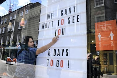 A worker prepares a shop window for reopening in London. England will begin its second phase of lockdown easing next week, with restaurants and retail shops set to reopen on April 12. EPA