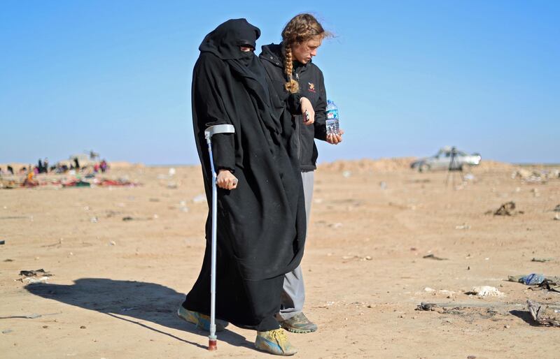 Civilians fleeing fighting between Syrian Democratic Forces (SDF) and ISIS militants in the frontline Syrian village of Baghuz, await to be screened and registered by the SDF.  AFP