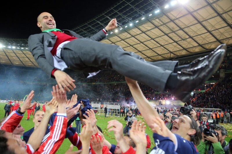 Bayern Munich head coach Pep Guardiola, top, is thrown into the air by his players after they beat Borussia Dortmund in the German Cup final. Kay Nietfeld / EPA / May 17, 2014