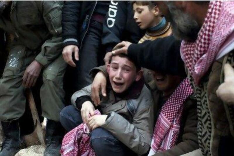 Ahmed, centre, mourns his father Abdulaziz Abu Ahmed Khrer, who was killed by a Syrian Army sniper, during his funeral in Idlib, northern Syria. Thousands of Syrian children have been killed and many more have been traumatised by the 18-month civil war, a new report says.