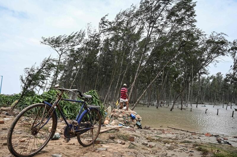 Residents collect debris from a damaged area near a beach after Cyclone Yaas hit India's east coast in the Bay of Bengal in Digha. AFP