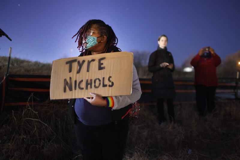 A protester in Memphis with a home-made placard bearing Mr Nichols's name. AFP