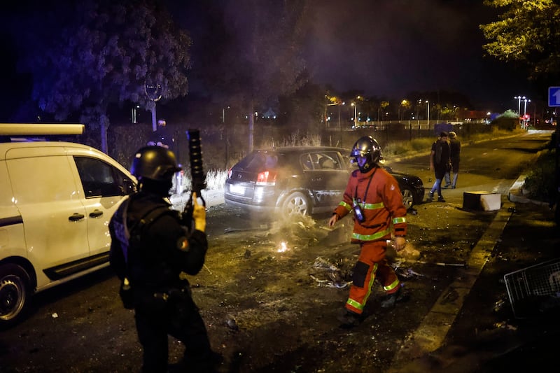 Firefighters and police at the scene of protests in Paris. EPA