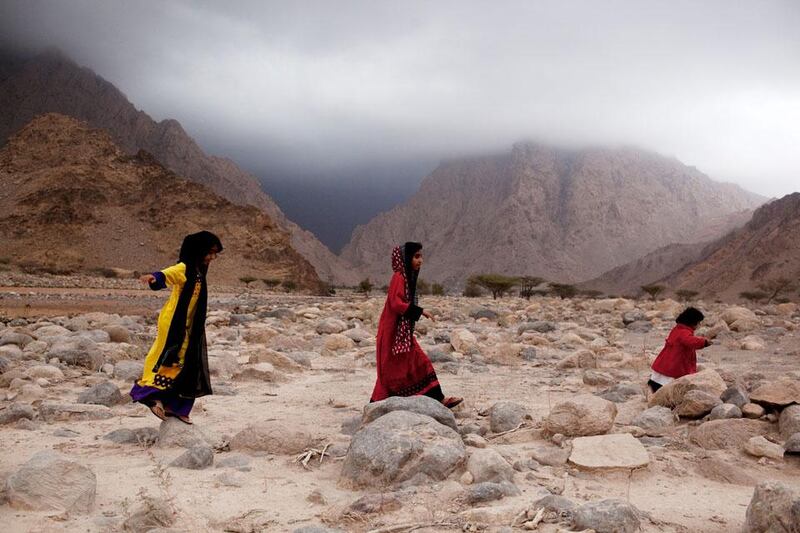 Local children play as they wait to be able to cross a washed out road in Wadi Khab Shamis north of Dibba in Musandam, Oman on February 18, 2012. Light rain overnight led to the road being washed out, holding up traffic for about three hours. Christopher Pike / The National