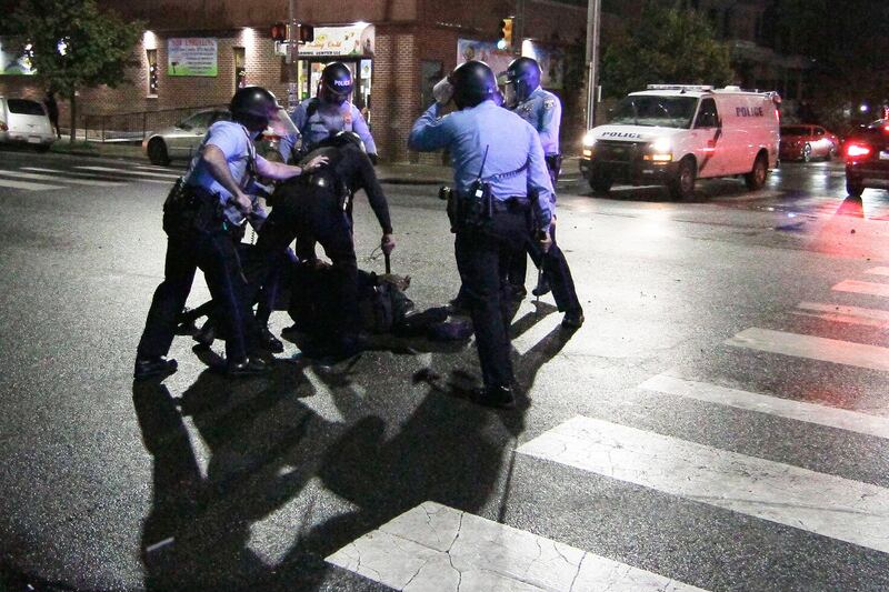 Police surround a man after chasing him down during a violent protest after police shot and killed a 27-year-old Black man on a Philadelphia street early Tuesday, Oct. 27, 2020. (Elizabeth Robertson/The Philadelphia Inquirer via AP)