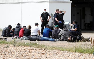 Migrants rescued from the English Channel following their departure from northern France are processed by officers, in Dungeness, Britain. Reuters