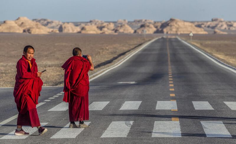 Buddhist monk's cross the desert road in Yardang Geopark also known as Devils Town near Dunhuang. All photos by  EPA