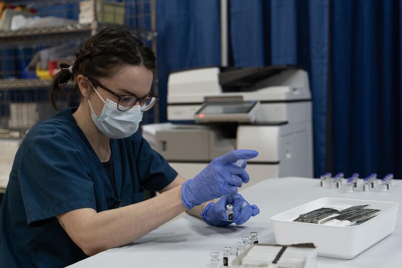 A healthcare worker prepares a dose of the Covid-19 vaccine. Willy Lowry / The National