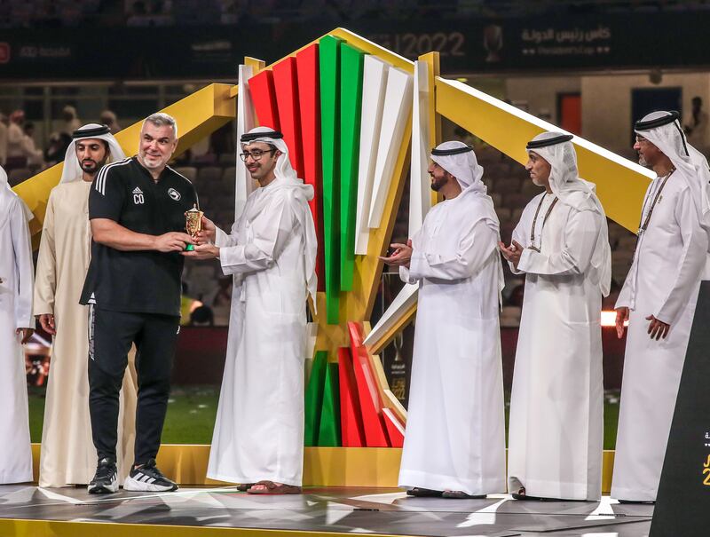 Sheikh Abdullah bin Zayed bin Sultan Al Nahyan gives a trophy to Sharjah manager Cosmin Olaroiu. Victor Besa / The National
