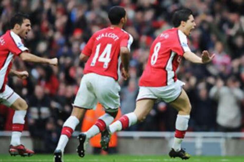 Arsenal's two-goal hero Samir Nasri, right, wheels away in celebration.