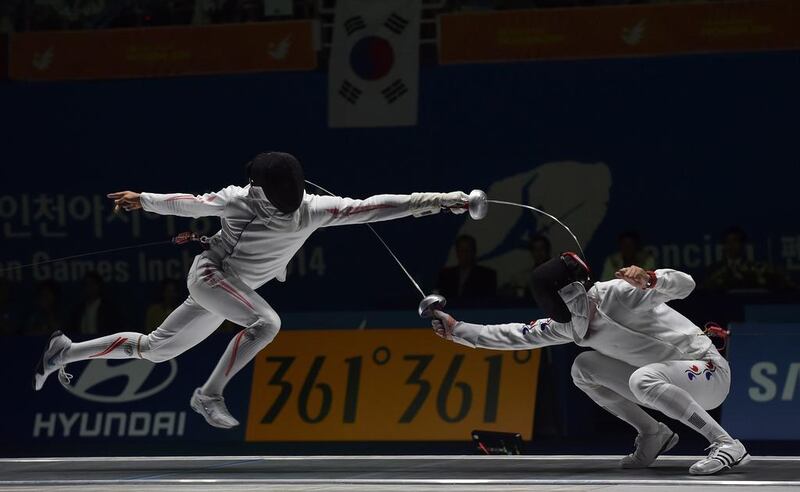 Japan’s Kazuyasu Minobe (L) duels with South Korea’s Jung Jinsun during the men’s epee team fencing finals at Goyang gymnasium during the 2014 Asian Games in Incheon on September 23, 2014. AFP PHOTO/ Prakash SINGH