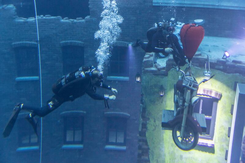 The divers move the display motorcycle. 
