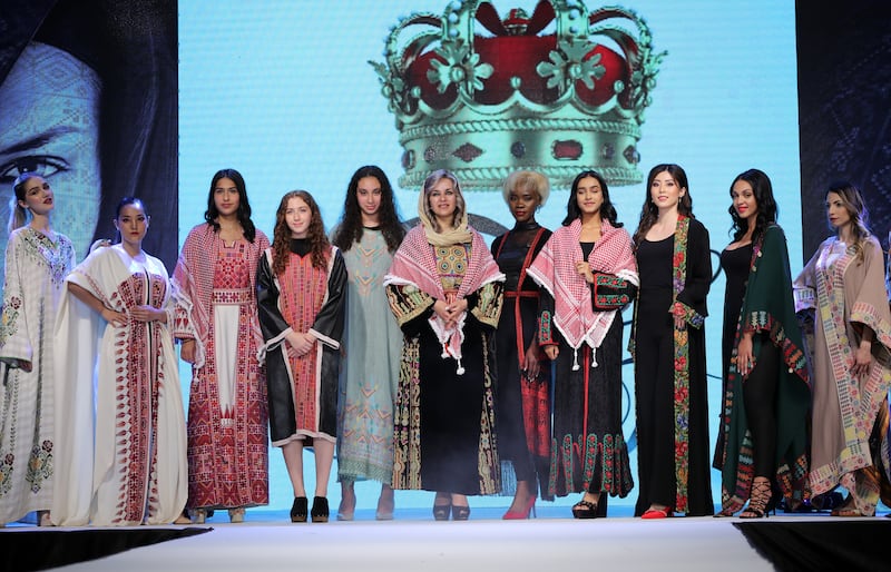 Fatima Abu Rub (C) appears on the catwalk with models wearing creations from her collection.