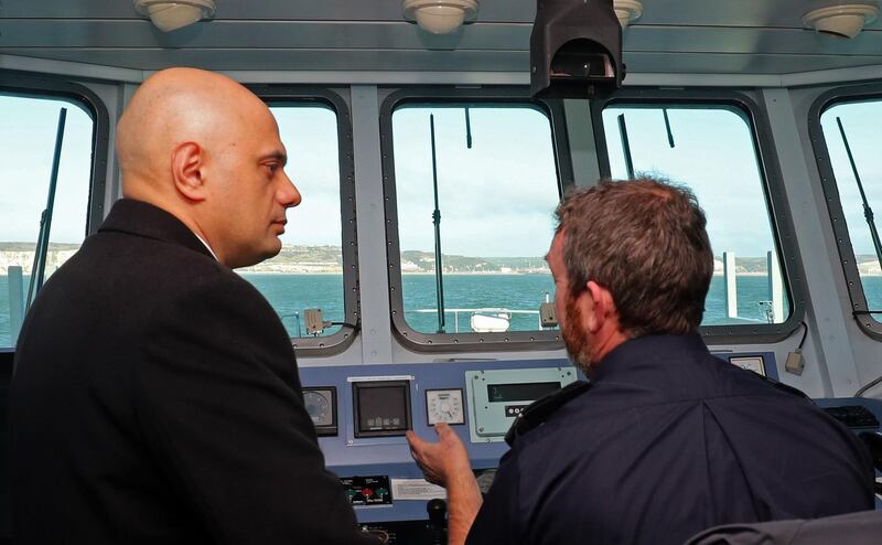 Britain's Home Secretary Sajid Javid (L) talks with UK Border Force staff onboard of Border Force cutter, HMC Searcher, on the Dover Strait off the coast of Dover, in south-east England on January 2, 2019. Britain announced earlier this week it will deploy two border patrol ships in the Channel in response to a surge in migrants crossing from France in dinghies. Javid, Britain's interior minister, said the Border Force ships would balance protecting human life with protecting Britain's borders. / AFP / POOL / Gareth Fuller
