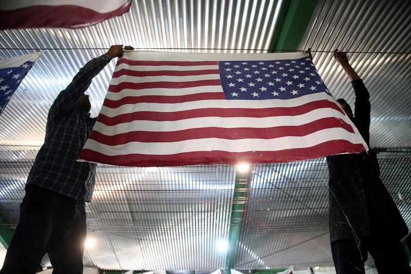 Iranian workers collect altered Israeli flags at a large factory that males US and Israeli flags for Iranian protesters to burn in Khomein City. West Asia News Agency via Reuters