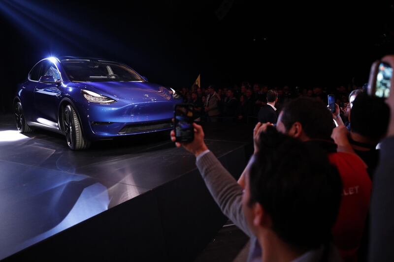 Attendees take photographs of the Tesla Inc. Model Y crossover electric vehicle. Bloomberg