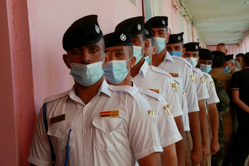 Members of Iraq's security forces wait to vote on Friday, two days before the country's parliamentary elections. AP Photo