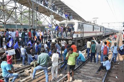 Members of the Indian Dalit community block a train at a station during a countrywide strike against the Supreme Court order that allegedly diluted the Scheduled Castes and Scheduled Tribes (Prevention of Atrocities) Act, in Mathura in Uttar Pradesh state on April 2, 2018.
A Supreme Court order banned automatic arrests of people involved in cases of alleged harassment of members of the Scheduled Castes and Scheduled Tribes community. / AFP PHOTO / -