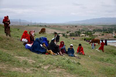 Afghan residents, whose houses are swamped with mud, gather on a hillside. AFP