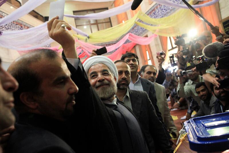 Presidential candidate Hassan Rohani shows his ballot before casting it during the Iranian presidential election in Tehran June 14, 2013. Millions of Iranians voted to choose a new president on Friday, urged by Supreme Leader Ayatollah Ali Khamenei to turn out in force to discredit suggestions by arch foe the United States that the election would be unfair. REUTERS/Yalda Moayeri  (IRAN - Tags: POLITICS ELECTIONS) *** Local Caption ***  CJF13_IRAN-ELECTION_0614_11.JPG