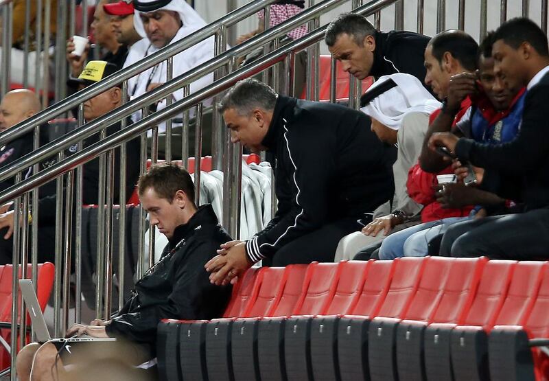 Al Ahli manager Cosmin Olaroiu leans over to look at performance analyst Chris Loxton's laptop during an Arabian Gulf League game against Dubai club in January, which Al Ahli won 4-2. Pawan Singh / The National