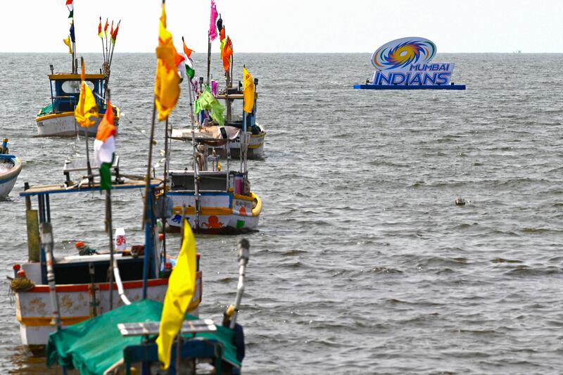 Boats are anchored near a logo of Indian Premier League's (IPL) Mumbai Indians team displayed ahead of the Tata IPL 2022 season, in the Arabian Sea off coast in Mumbai on March 25, 2022.  (Photo by Indranil MUKHERJEE  /  AFP)